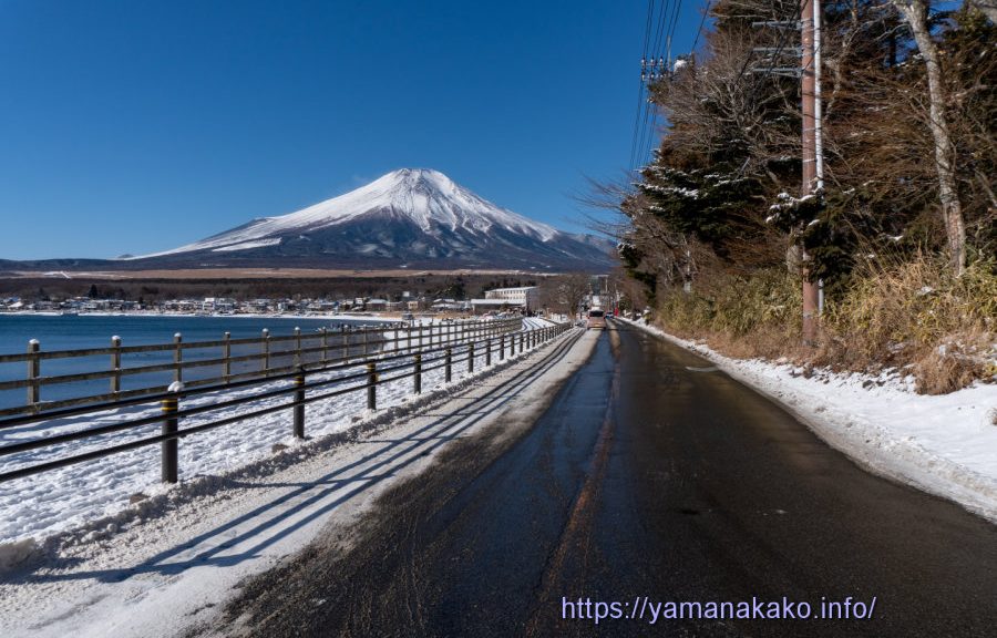 雪の残っている道路から望む富士山
